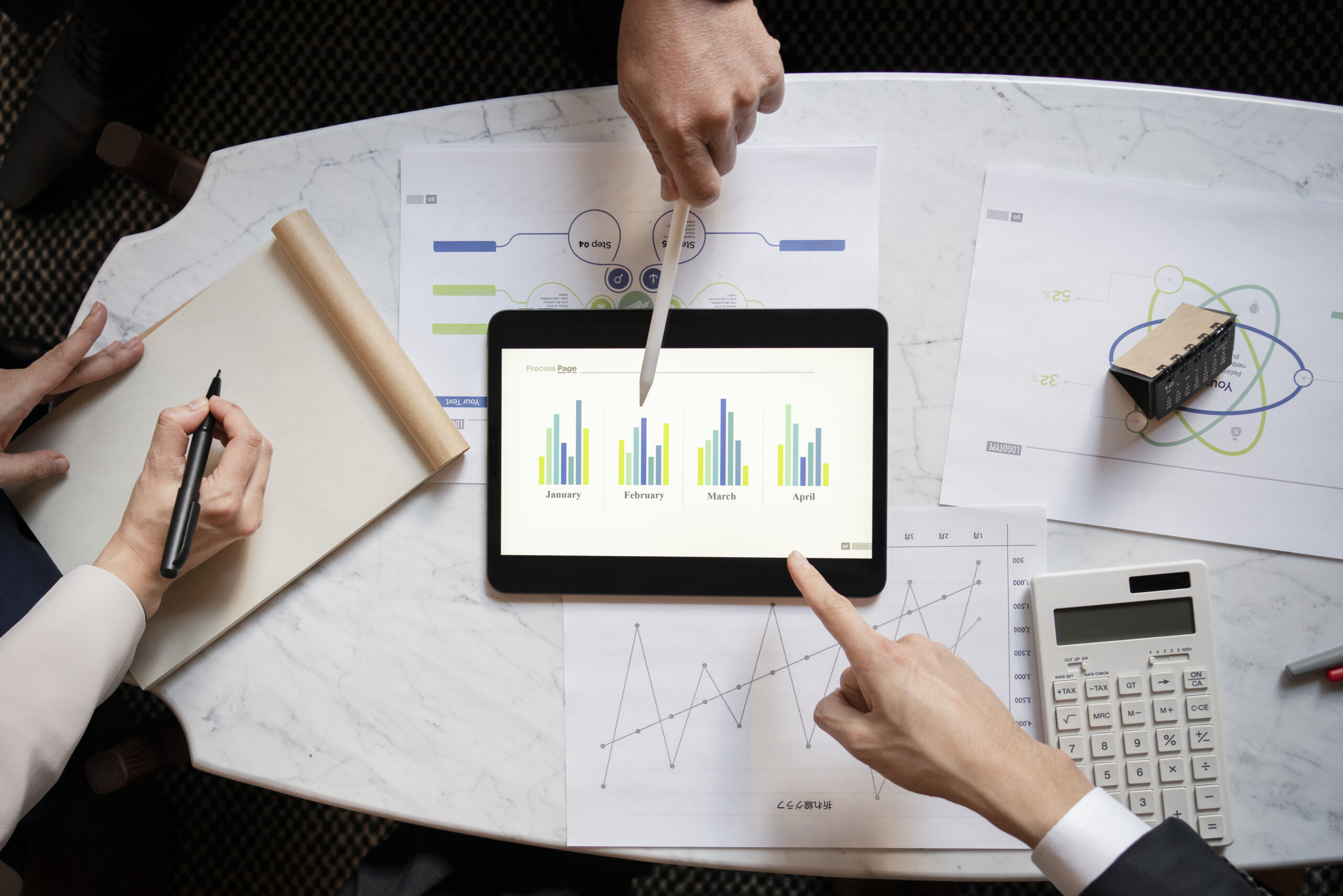 vista-superior-de-personas-de-negocios-que-trabajan-con-ipad Estrategias para alcanzar tus metas contables